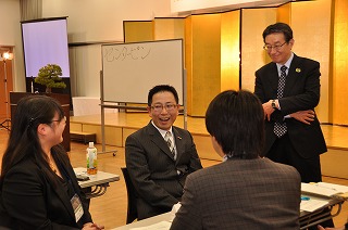写真：討論する高野塾長と受講生の様子