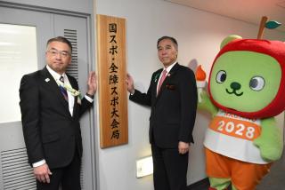 知事と局長が看板をかける様子